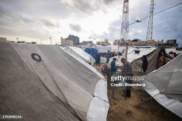 Displaced Palestinians outside temporary shelters at a camp, operated by the United Nations Relief and Works Agency , in Khan Younis, Gaza, on...