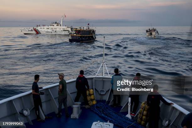 Philippine's military-chartered boats, Unaizah Mae 1, and ML Kalayaan move past a China Coast Guard Ship during a resupply mission for the BRP Sierra...