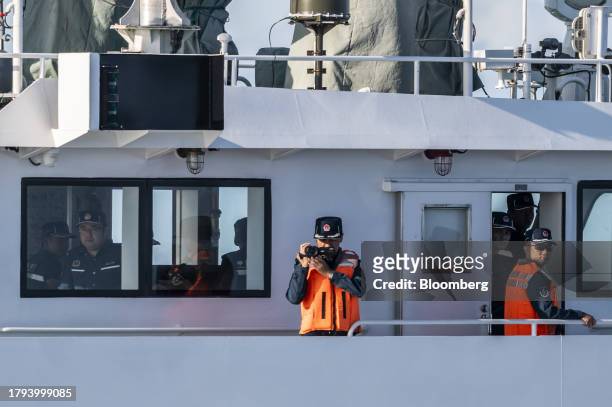 China Coast Guard personnel on lookout at a Philippine Coast Guard ship during a resupply mission for the BRP Sierra Madre, in the Second Thomas...