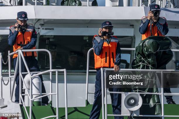 China Coast Guard personnel take pictures and videos of Philippine Coast Guard ships during a resupply mission for the BRP Sierra Madre, in the...