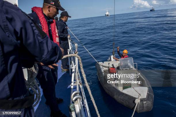 Philippine Coast Guard personnel prepare a rigid-hulled inflatable boat during a resupply mission for the BRP Sierra Madre, in the Second Thomas...