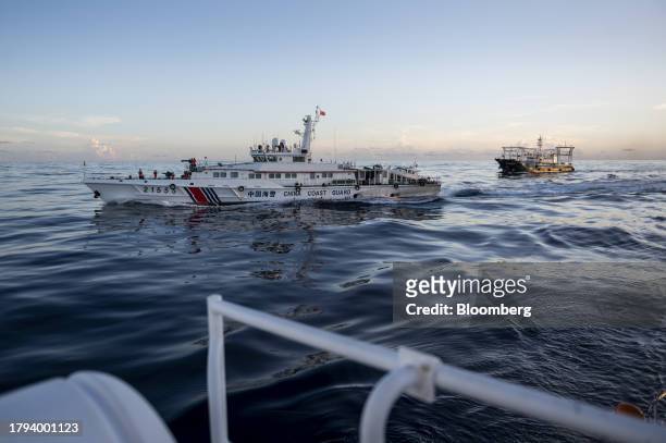 China Coast Guard ship and a Chinese fishing vessel, which Manila calls maritime militia, seen from the BRP Sindangan, during a resupply mission for...