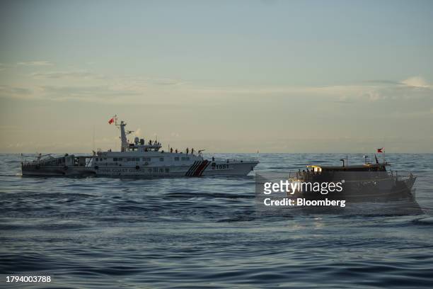 Philippine's military-chartered boat, Unaizah Mae 1, moves past a China Coast Guard ship during a resupply mission for the BRP Sierra Madre, in the...