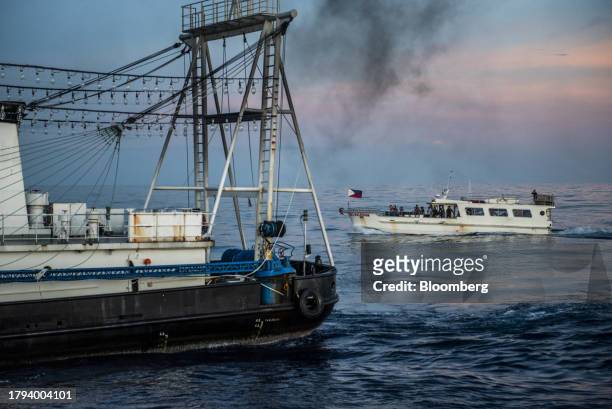 Philippines' military-chartered boat, ML Kalayaan moves near a Chinese fishing vessel which Manila calls maritime militia vessel during a resupply...