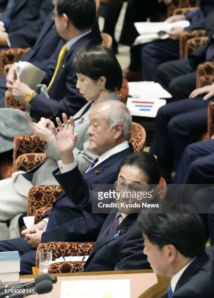 Japanese Prime Minister Fumio Kishida raises his hand to speak at a House of Representatives budget committee session in Tokyo on Nov. 21, 2023.