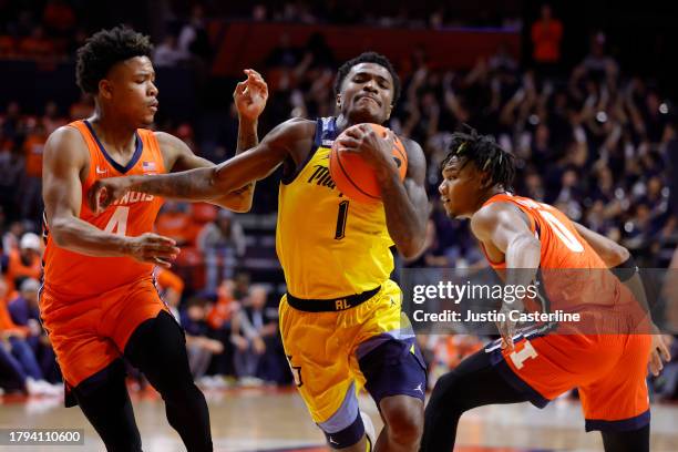 Kam Jones of the Marquette Golden Eagles drives to the basket against Justin Harmon and Terrence Shannon Jr. #0 of the Illinois Fighting Illini...