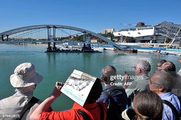 People gather as the new Raymond Barre bridge is placed outside the new Confluences Museum in Lyon, southeastern France, on September 3, 2013. AFP...