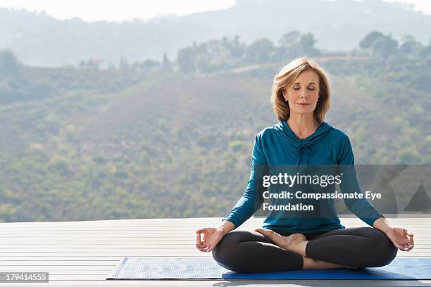 woman practicing yoga - meditieren stock-fotos und bilder