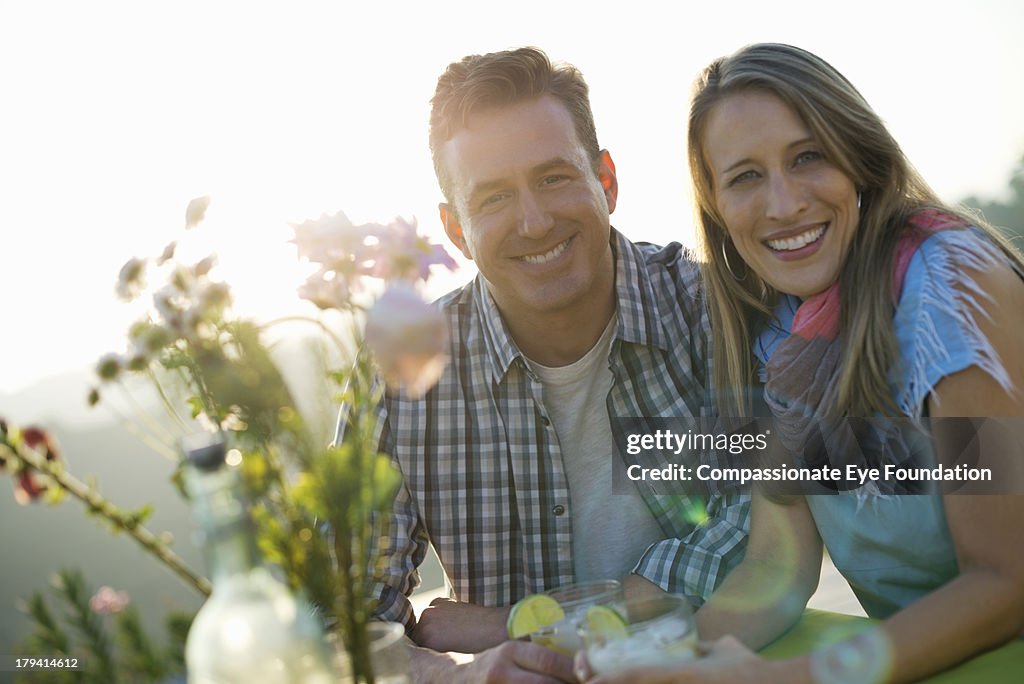 Smiling couple having drinks outdoors