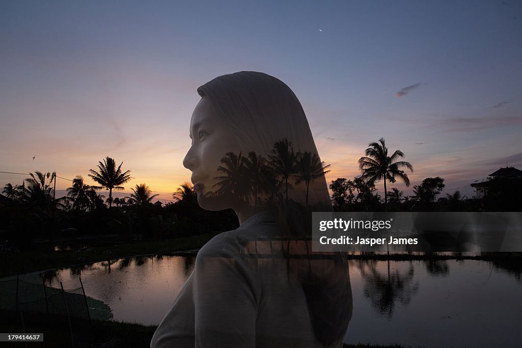 Composite image of young woman and palm trees