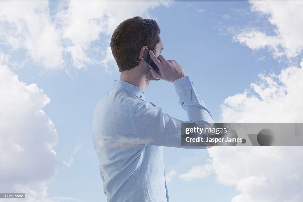 Composite of man talking on phone and blue sky