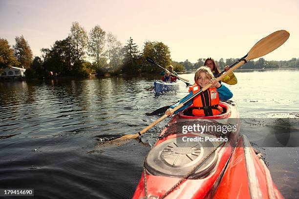 family paddling in a canoe on a lake - paddla bildbanksfoton och bilder