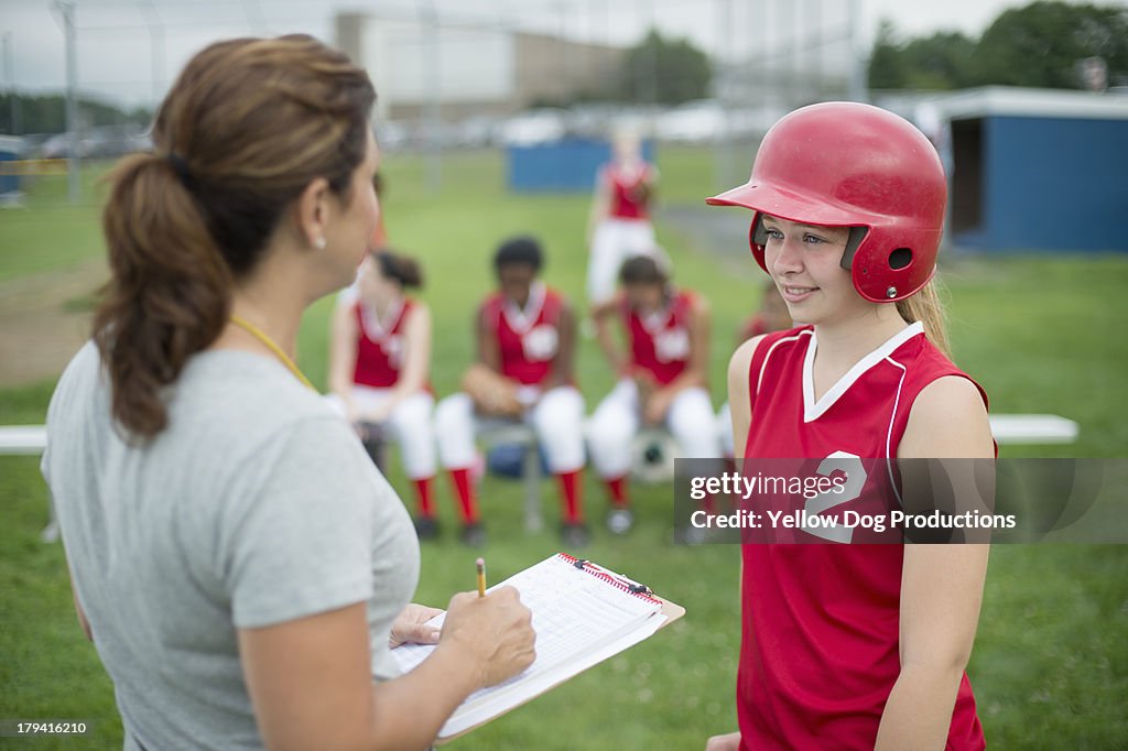 Coach Talking to Softball Player, teammates behind