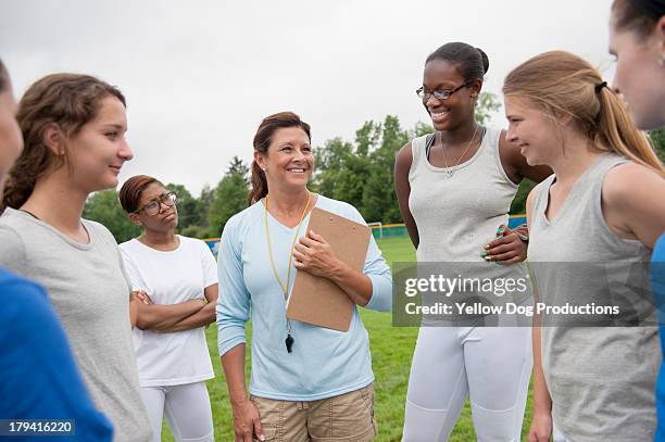 coach with high school athletes on field - dog whistle stock pictures, royalty-free photos & images