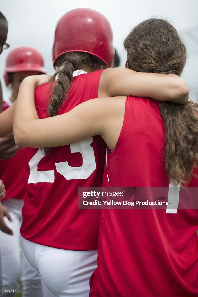 Back View of Girls Hugging at Softball Game