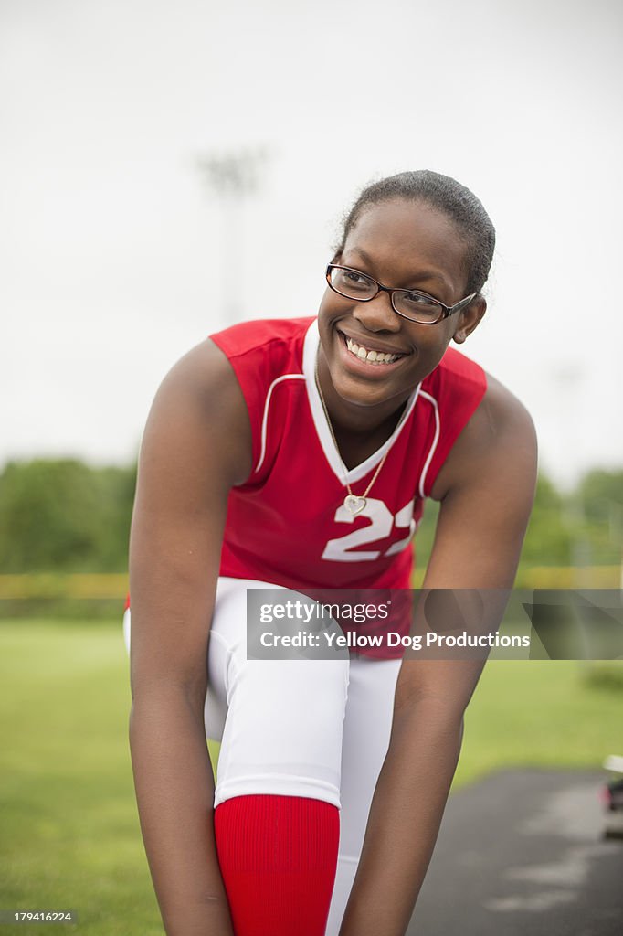 Smiling High School Softball Player tying shoe