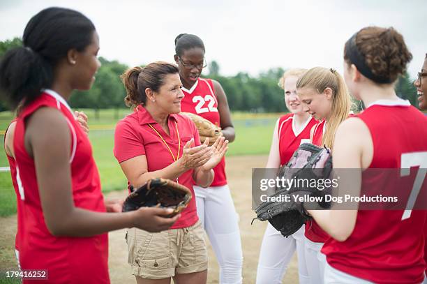 coach  talking to softball players - softball sport stock-fotos und bilder