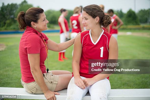 coach talking to softball player sitting on bench - dog whistle stock pictures, royalty-free photos & images