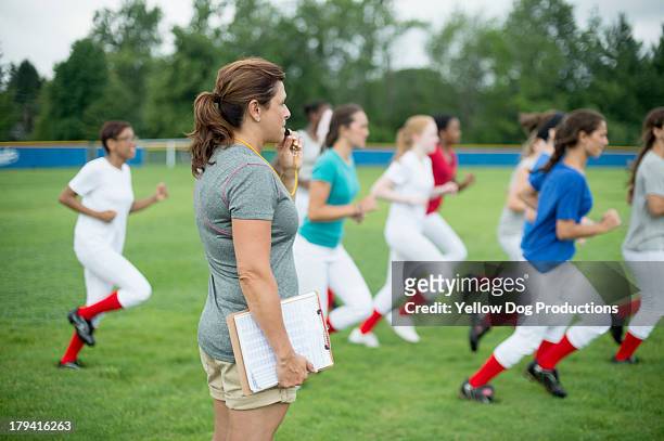 softball players running drill with coach - focus on sport 2013 stock pictures, royalty-free photos & images