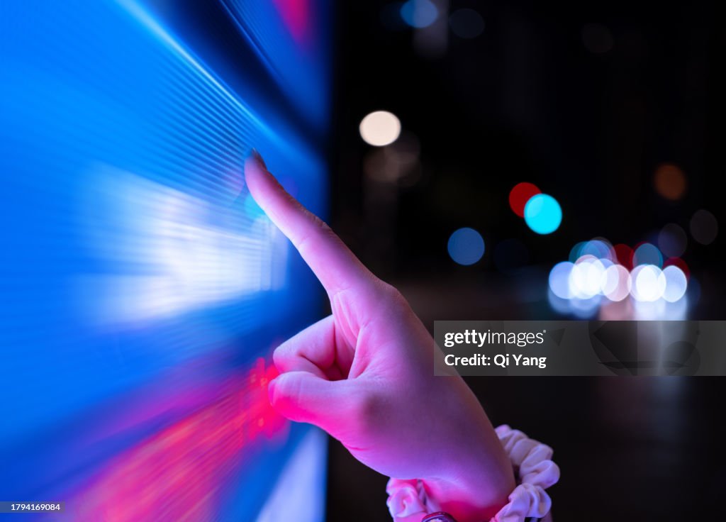 Close-up of using touch screen on street at night