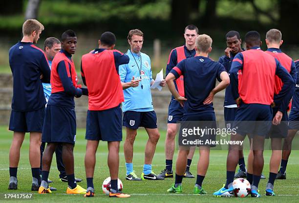 Gareth Southgate the manager of the England Under-21 talks to his players during a training session at St Georges Park on September 3, 2013 in...