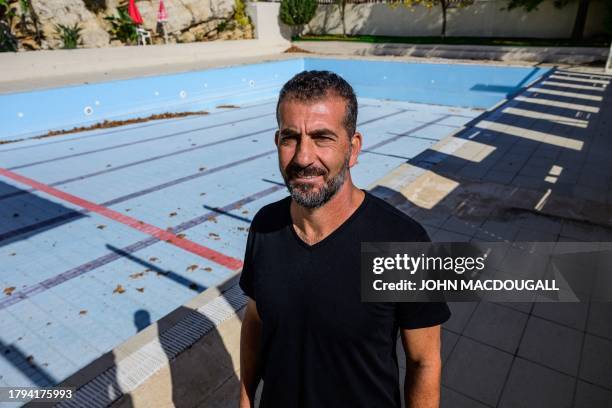 Beit Jann resident Ashraf Halabi, who faces a demolition order, poses next to the swimming pool he had built on his property, in the predominantly...