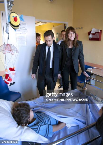 France's president Nicolas Sarkozy and his wife Carla Bruni-Sarkozy arrive to visit a child at the Saint-Denis children hospital, on December 19,...