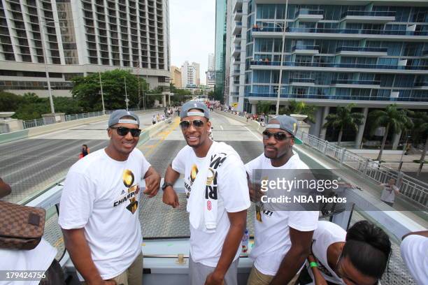 Mario Chalmers, Chris Bosh and LeBron James pose for a photo during a rally for the 2012 NBA Champions Miami Heat on June 25, 2012 at American...