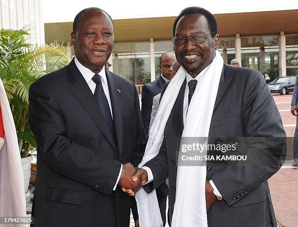 Ivory Coast President Alassane Ouattara , who is also the new ECOWAS organisation chairman, shakes hands with Mali's interim president Dioncounda...