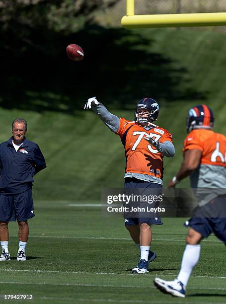 Denver Broncos guard Chris Kuper throws a pass to fellow lineman in drills during practice September 3, 2013 at Dove Valley.