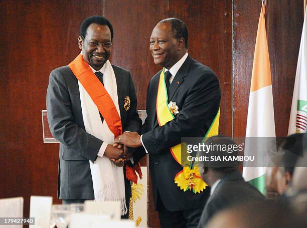 Ivory Coast President Alassane Ouattara , who is also the new ECOWAS organisation chairman, poses for a photograph after receiving a medal of honor...