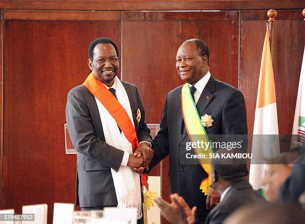 Ivory Coast President Alassane Ouattara , who is also the new ECOWAS organisation chairman, poses for a photograph after receiving a medal of honor...