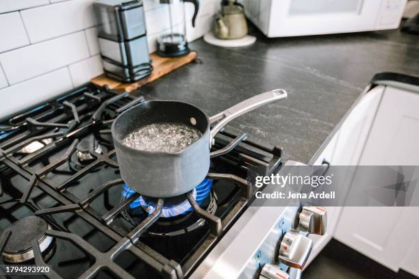 boiling water on stovetop, gas stove burner in kitchen, methane natural gas - boiling water stock pictures, royalty-free photos & images