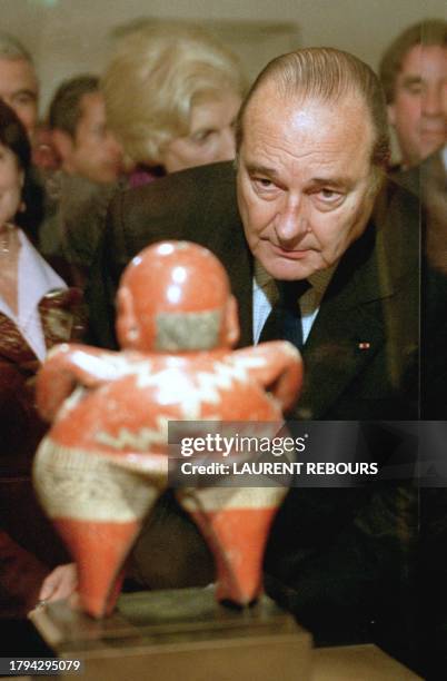 French President Jacques Chirac looks at a Mexican Chupicuano sculpture , Thursday April 13 during the inauguration of a new wing of the Louvre...