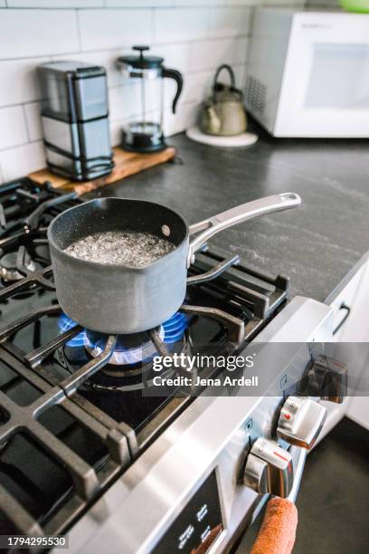 boiling pot on gas stove burner, domestic kitchen stovetop, hot water boiling in pot on stove - boiled stock pictures, royalty-free photos & images