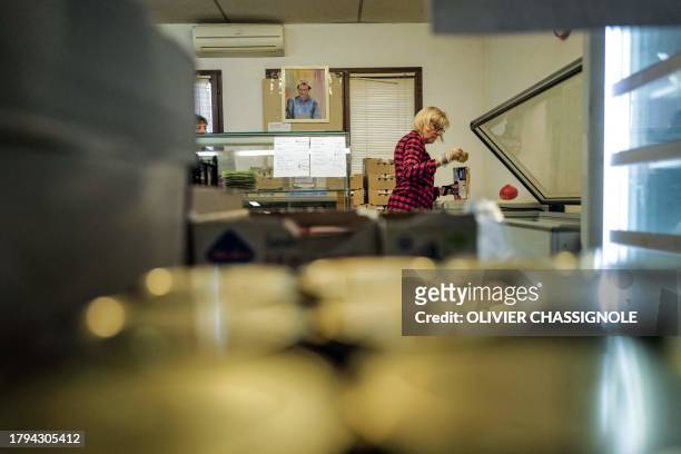 Volunteer of French charity "Les Restos Du Coeur" prepares meals on November 21, 2023 at a facility of the association in Grenoble, during the launch...