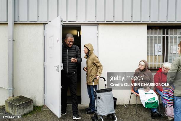 People arrive for a food distribution at a facility of French charity "Les Restos Du Coeur" on November 21, 2023 in Grenoble, during the launch of...
