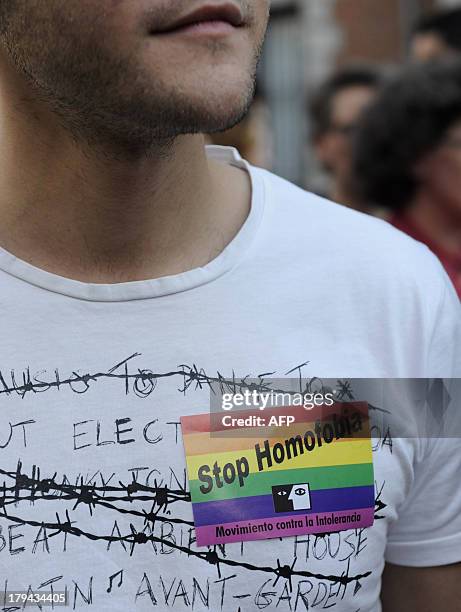 Demonstrator wears a tshirt with a rainbow flag sticker as he protests against homophobia and repression against gays in Russia, outside the Ministry...