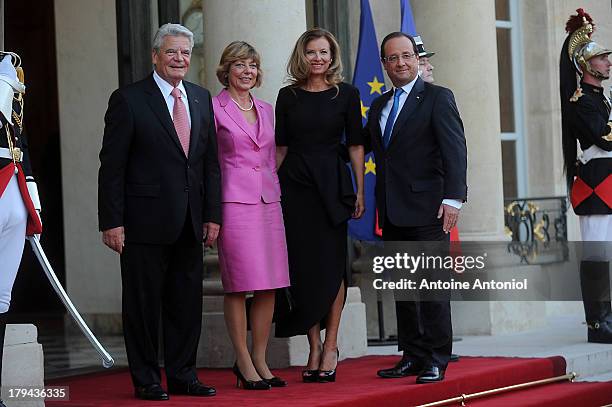 French President Francois Hollande and his companion Valerie Trierweiler pose with the German President's companion Daniela Schadt and the German...