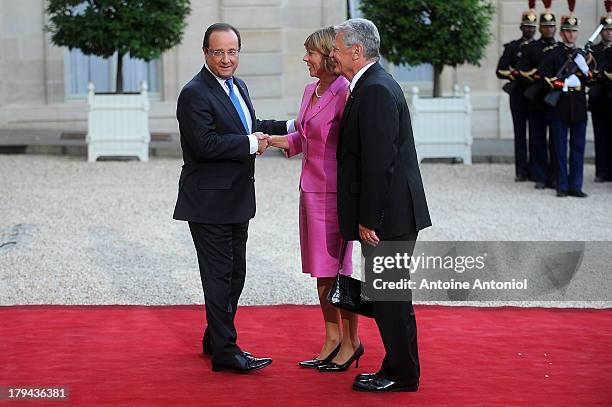 French President Francois Hollande welcomes German President's companion Daniela Schadt and German President Joachim Gauck at the Elysee Palace on...