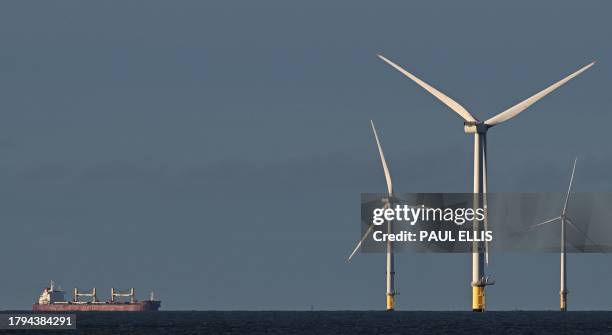 Bulk Carrier Kiran Marmara makes it way towards port in Liverpool, north west England, passing wind turbines in the Burbo Bank wind farm in the Irish...