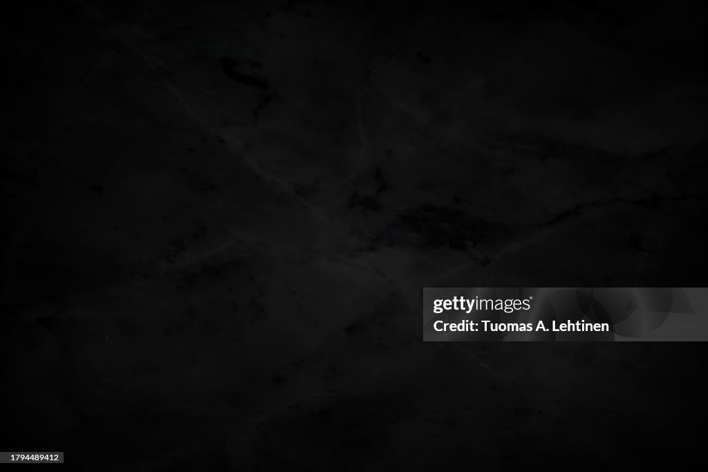 Close-up of dark gray, almost black, smooth and natural textured marble pattern background.