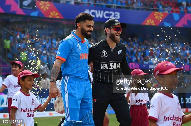 Virat Kohli of India and Kane Williamson of New Zealand interact while walking out onto the pitch prior to the ICC Men's Cricket World Cup India 2023...