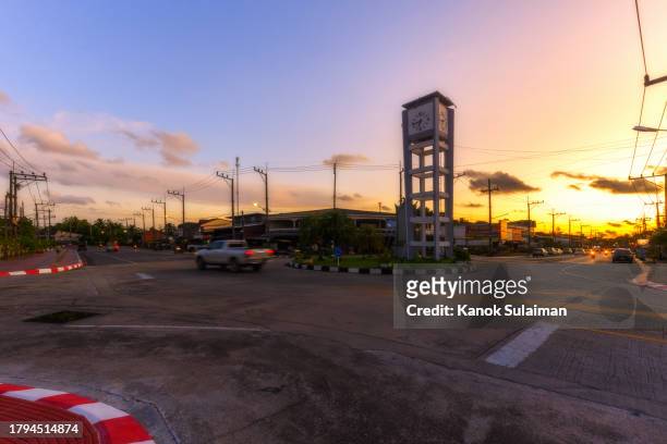 car driving pass clock tower with dramatic sky at sunset - a blue car driving in speed stock pictures, royalty-free photos & images