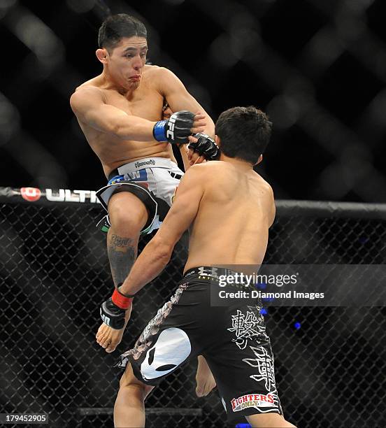 Erik Perez jumps up to knee Takeya Mizugaki during a bantamweight bout during UFC Fight Night 27 Condit v Kampmann 2 at Bankers Life Field House in...