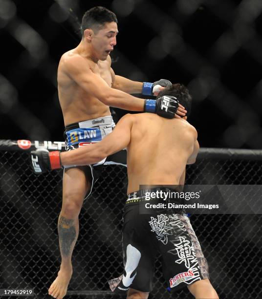 Erik Perez jumps up to knee Takeya Mizugaki during a bantamweight bout during UFC Fight Night 27 Condit v Kampmann 2 at Bankers Life Field House in...