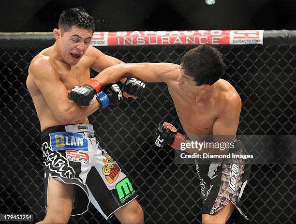 Takeya Mizugaki connects with a punch to the head of Erik Perez during a bantamweight bout during UFC Fight Night 27 Condit v Kampmann 2 at Bankers...