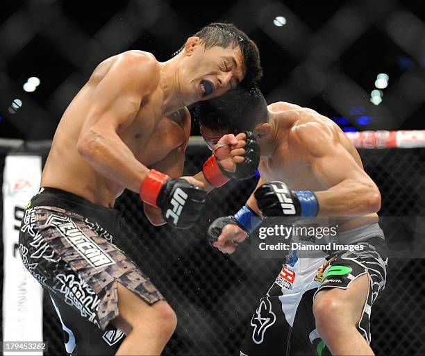 Takeya Mizugaki looks for an opening to throw a punch at Erik Perez during a bantamweight bout during UFC Fight Night 27 Condit v Kampmann 2 at...