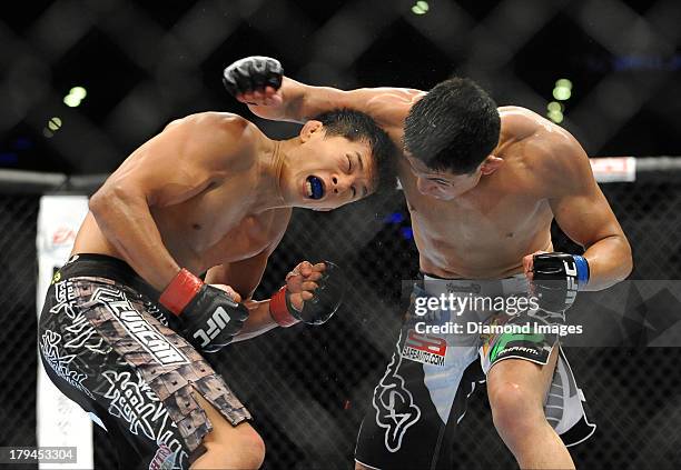 Takeya Mizugaki dodges a punch from Erik Perez during a bantamweight bout during UFC Fight Night 27 Condit v Kampmann 2 at Bankers Life Field House...