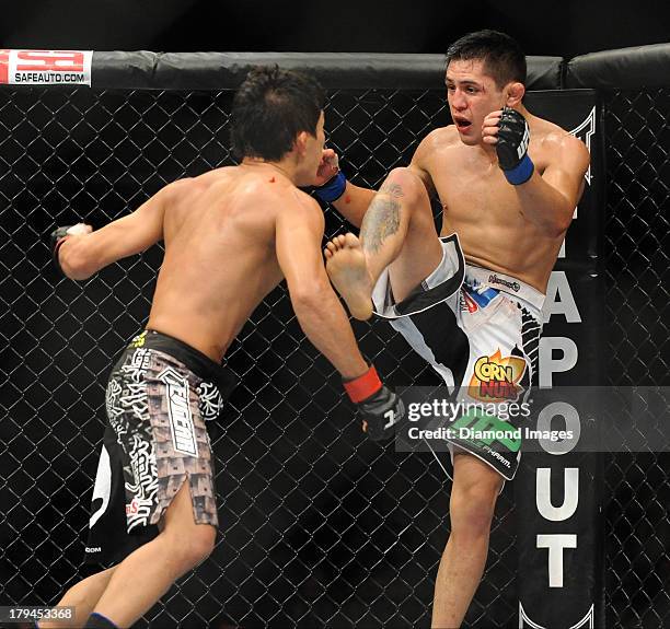 Erik Perez throws a kick to the body of Takeyta Mizugaki during a bantamweight bout during UFC Fight Night 27 Condit v Kampmann 2 at Bankers Life...